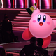 Kirby holds up a Grammy triumphantly while standing adorably on the award stage.